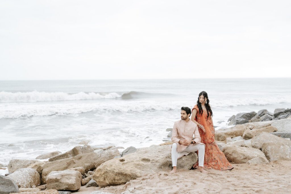 South Asian wedding Couple posing on rocky beach