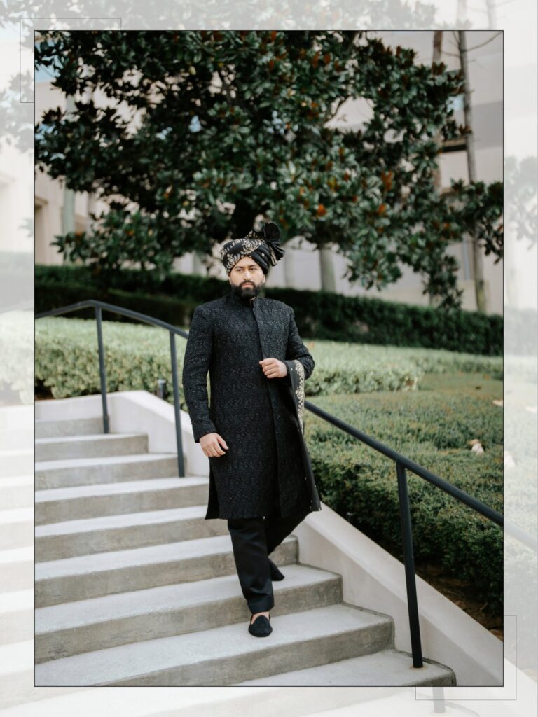 Amen & Shoaib’s Stunning South Asian Wedding at Signia by Hilton & Waldorf Astoria Orlando 16 Groom in a black sherwani and embroidered turban walking down outdoor steps on his shaadi day in Orlando