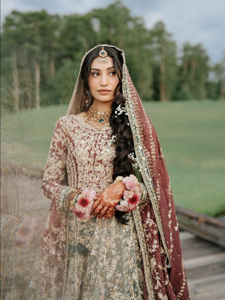 Amen & Shoaib’s Stunning South Asian Wedding at Signia by Hilton & Waldorf Astoria Orlando 4 Bride in a pale green and gold embroidered outfit with a red dupatta and floral jewelry for her mehndi