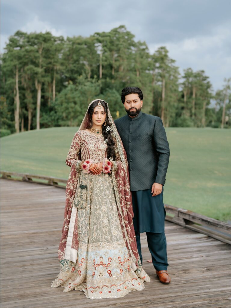 Amen & Shoaib’s Stunning South Asian Wedding at Signia by Hilton & Waldorf Astoria Orlando 2 Bride in a pistachio and gold embroidered outfit with the groom in a grey sherwani on a boardwalk at Bonnet Creek, Orlando
