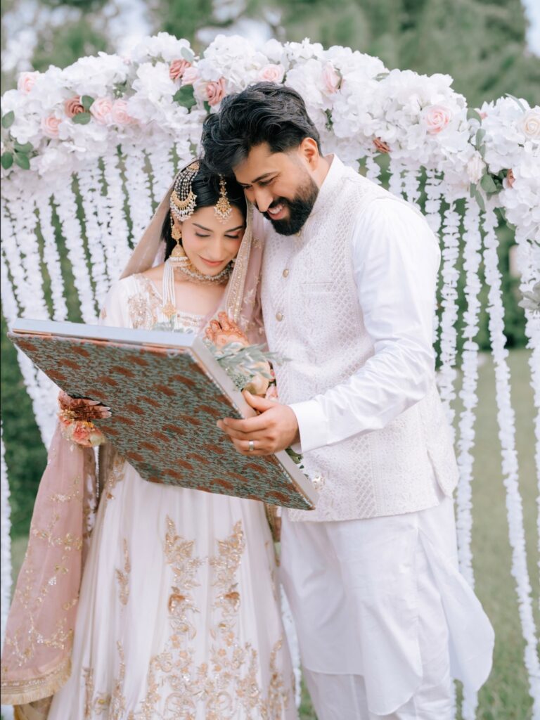 Amen & Shoaib’s Stunning South Asian Wedding at Signia by Hilton & Waldorf Astoria Orlando 6 Couple smiling while looking into the mirror during the aarsi mushaf ceremony at their nikkah near Disney, Orlando
