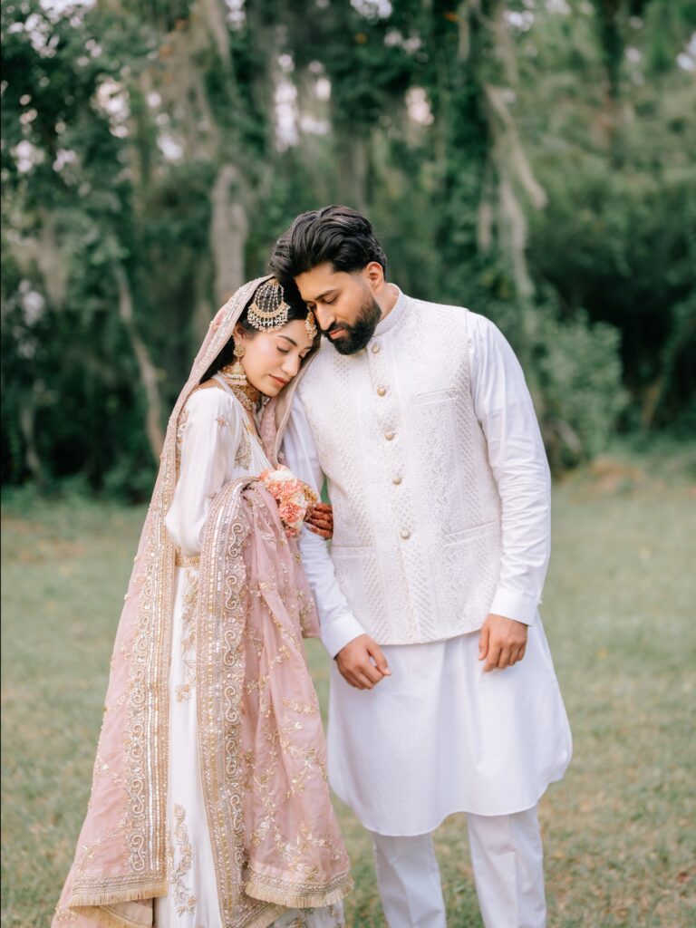 Amen & Shoaib’s Stunning South Asian Wedding at Signia by Hilton & Waldorf Astoria Orlando 9 Bride in a blush and ivory lehenga leaning on the groom in a white kurta at their nikkah at Bonnet Creek, near Disney in Orlando