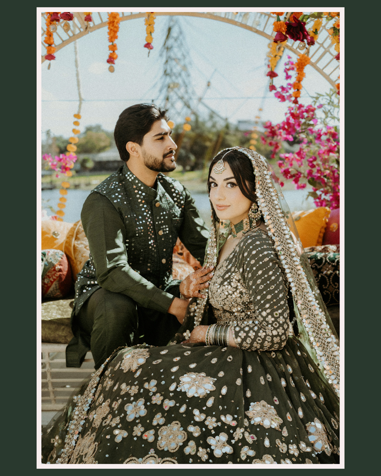 Indian Wedding Venues in Orlando: A Photographer’s Guide to the Top Hotels 3 Mehndi couple in green outfits on a cushioned stage under a flower arch by the water, Orlando mehndi photography