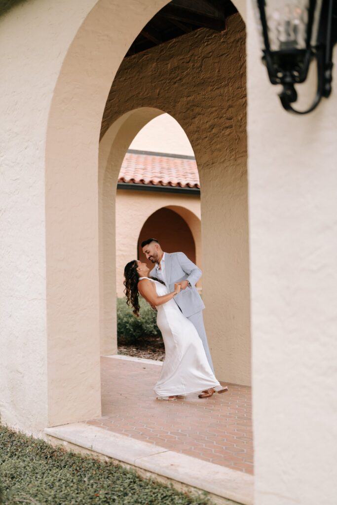 Rahul & Nirali’s Romantic Rollins College Engagement Session 8 Groom-to-be dipping his fiancée through layered arches, Winter Park engagement session