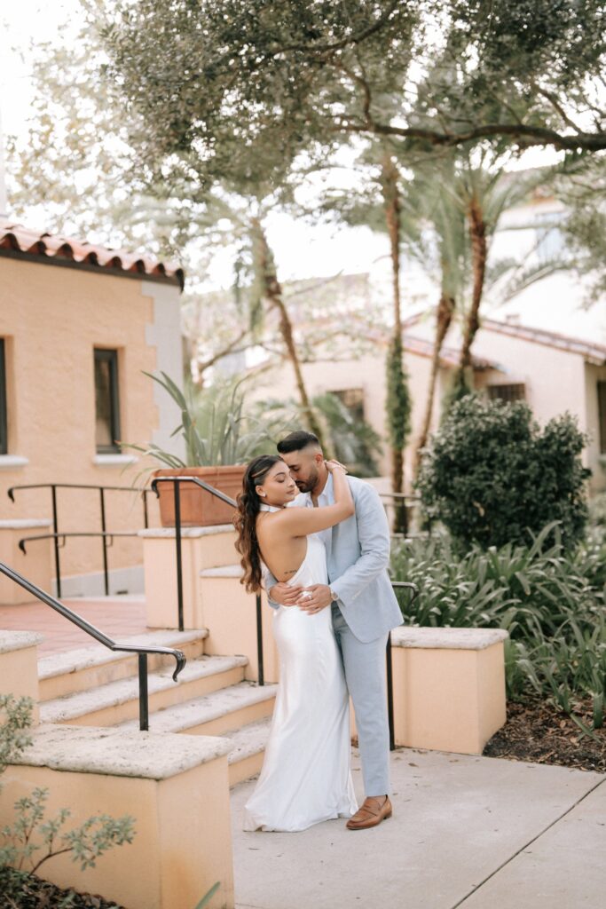 Rahul & Nirali’s Romantic Rollins College Engagement Session 12 Couple embracing by terracotta planters and stone steps, Rollins College engagement session