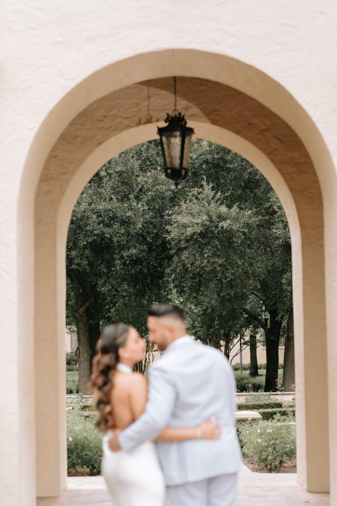 Rahul & Nirali’s Romantic Rollins College Engagement Session 5 Soft-focus kiss framed by a Spanish archway, Orlando engagement photographer