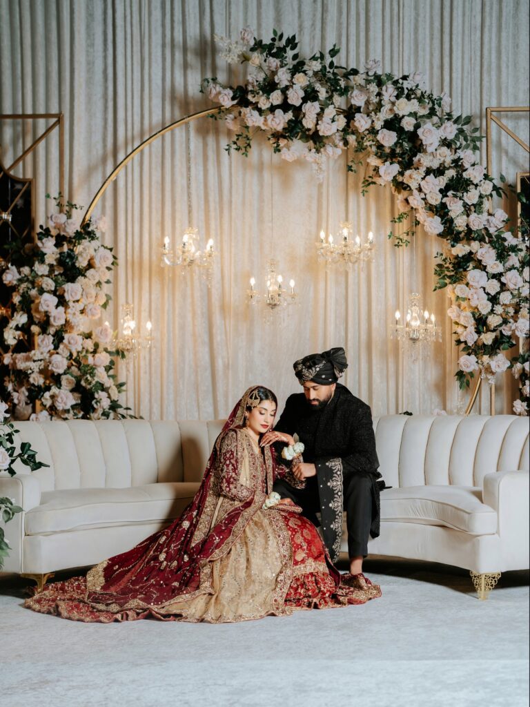 Amen & Shoaib’s Stunning South Asian Wedding at Signia by Hilton & Waldorf Astoria Orlando 22 Bride and groom seated on a white floral shaadi stage in a resort ballroom at Bonnet Creek, Orlando