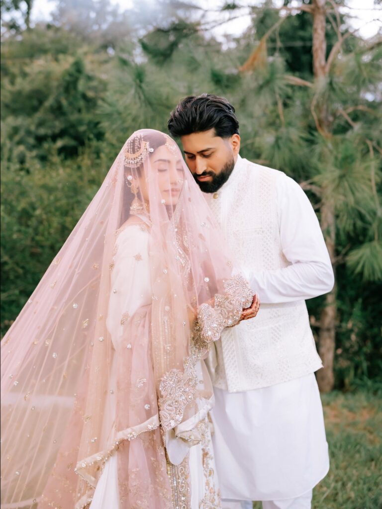 Amen & Shoaib’s Stunning South Asian Wedding at Signia by Hilton & Waldorf Astoria Orlando 10 Groom in white embracing the bride in a blush dupatta, South Asian nikkah portraits in Orlando, Florida
