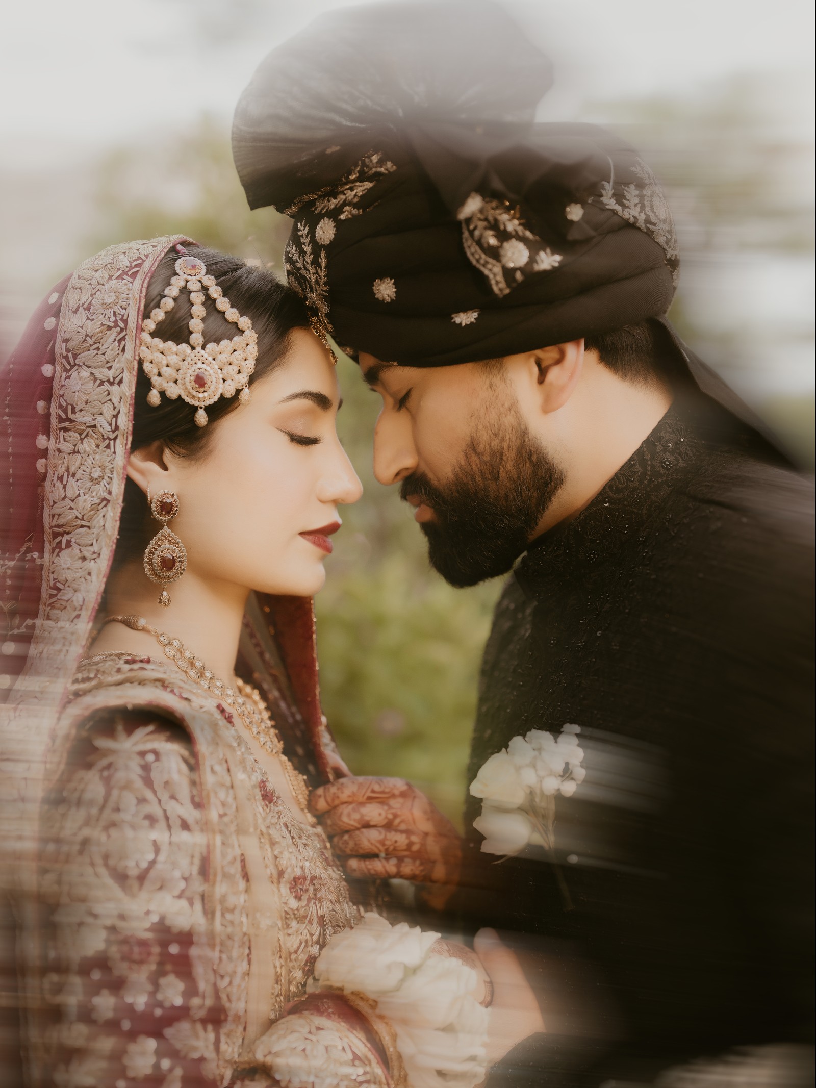 Bride and groom in maroon and black touching foreheads, by South Asian wedding photographer in Orlando Noor K Photography